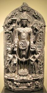 God Vishnu, flanked on the right by Lakshmi and left by his sister Saraswati. Pala Period. 12th century stone sculpture.